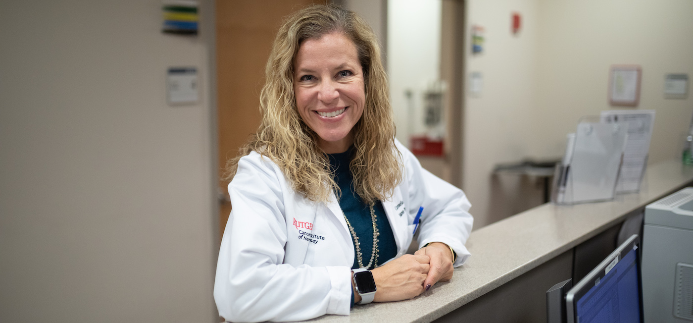 photo of a smiling blonde nurse standing at a clinic station