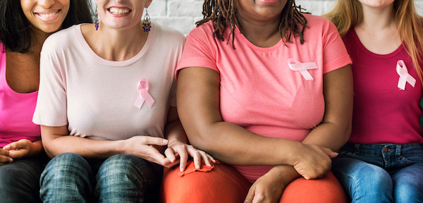 group of women in shirts wearing pink breast cancer ribbons