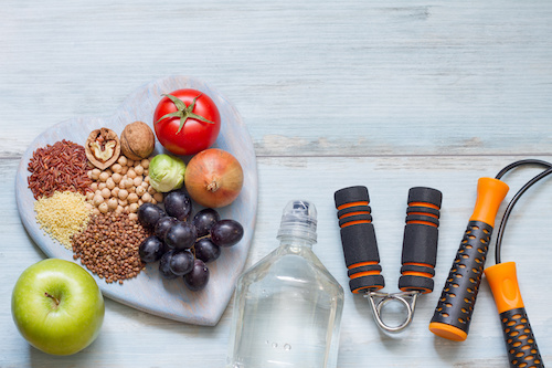 heart healthy foods on a heart shaped plate next to workout tools and a water bottle