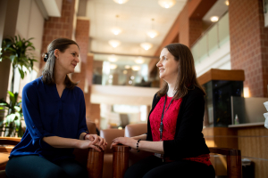 two women sitting in the lobby of the cancer institute having a conversation